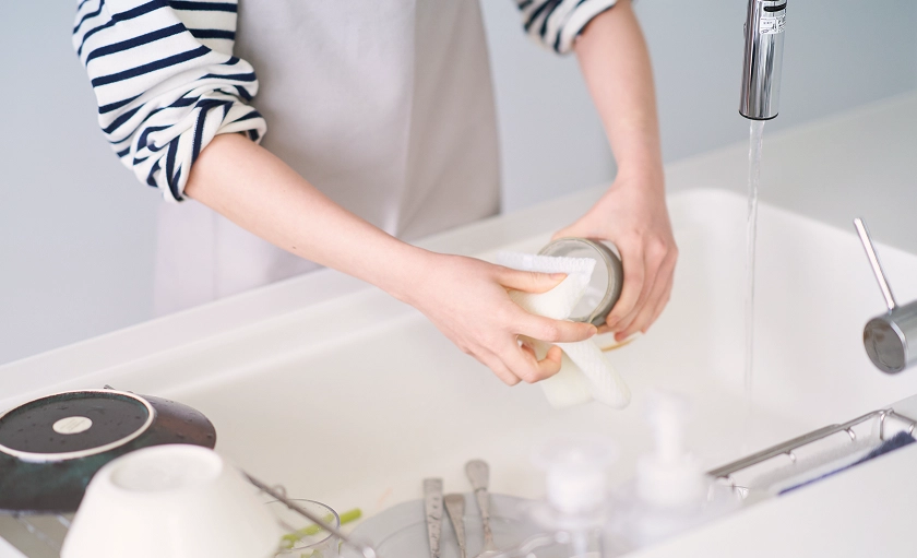 キッチンで食器を洗っている女性